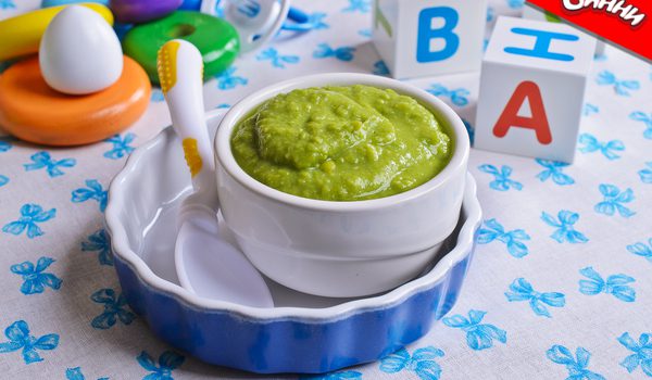 Puree of green in the small bowl is on the background of childrens toys